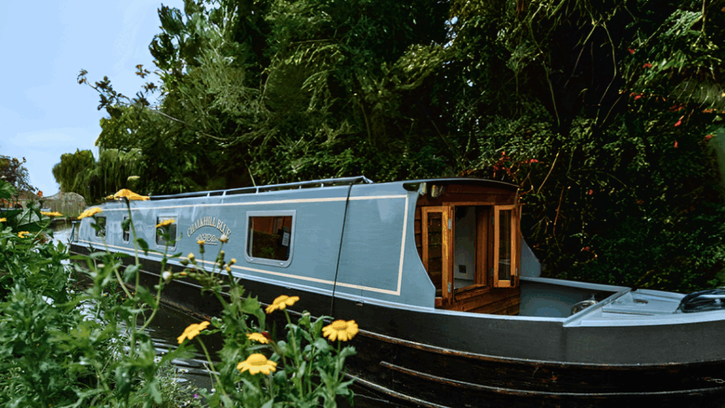 Luxury narrowboat holiday on a peaceful canal in spring with reflections on the water.