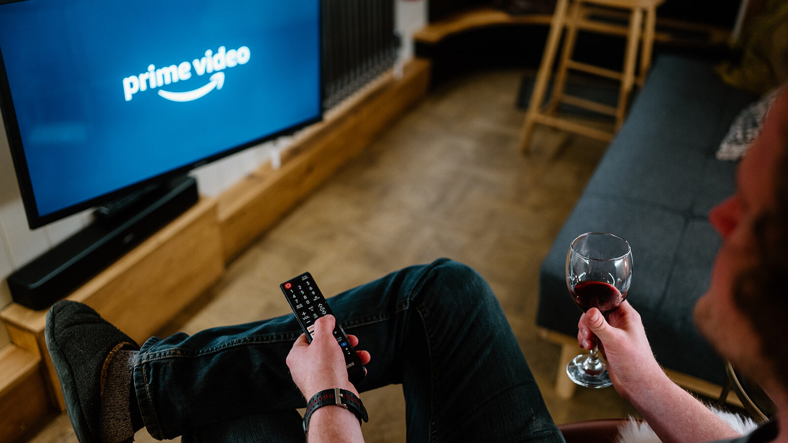 Evening scene inside a narrowboat with a glass of wine on the table and a TV screen showing Amazon Prime, creating a cosy onboard atmosphere