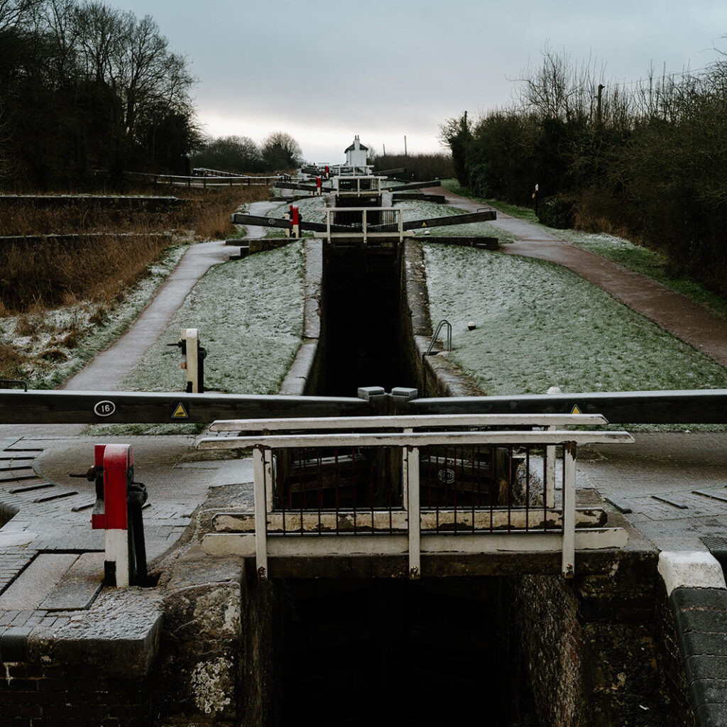 Foxton Locks on a frosty winter morning, with still water and crisp ground covered in frost.